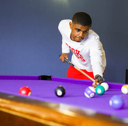 Student playing pool in a Res Hall