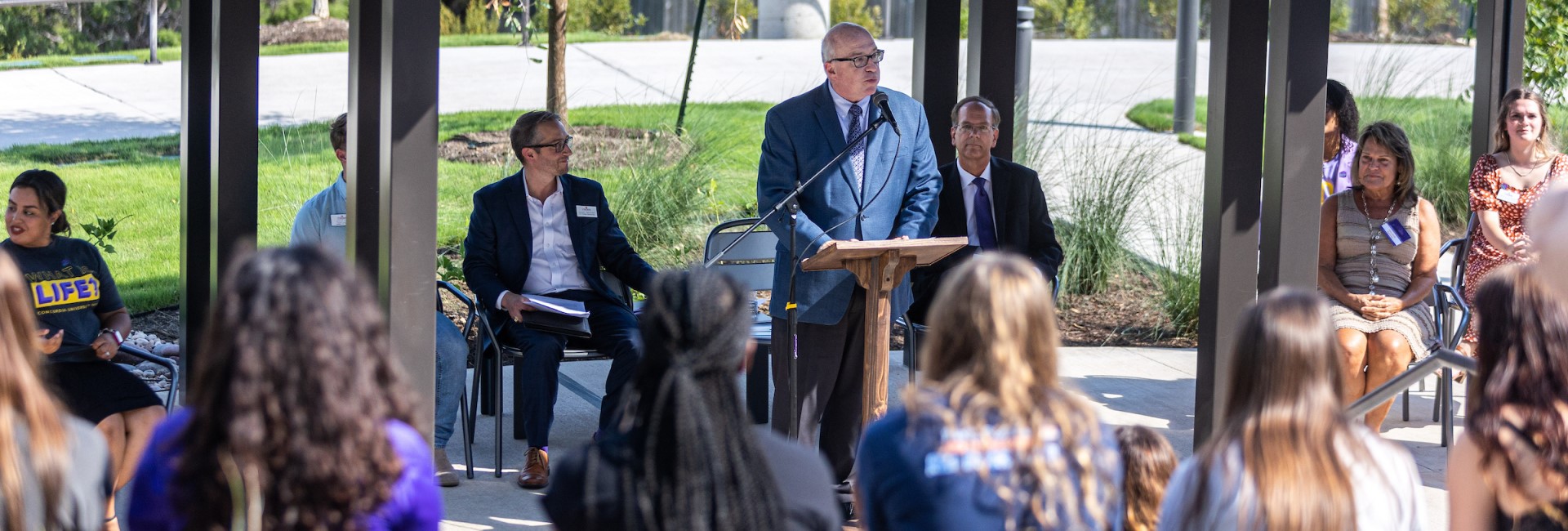 Dr. Christian delivering a speech to student and staff