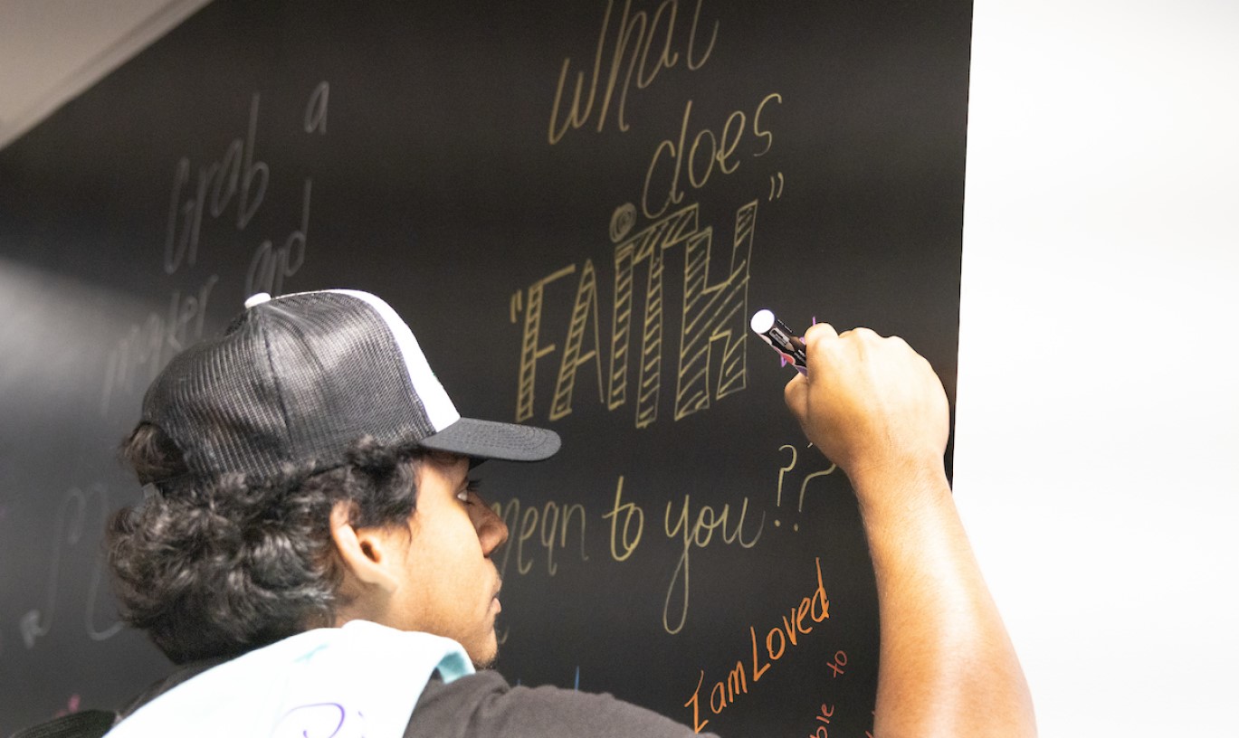 A student writing on a chalk board