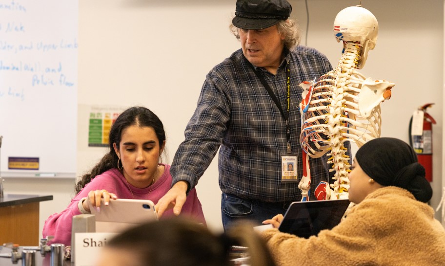 A professor guiding students in a biology class