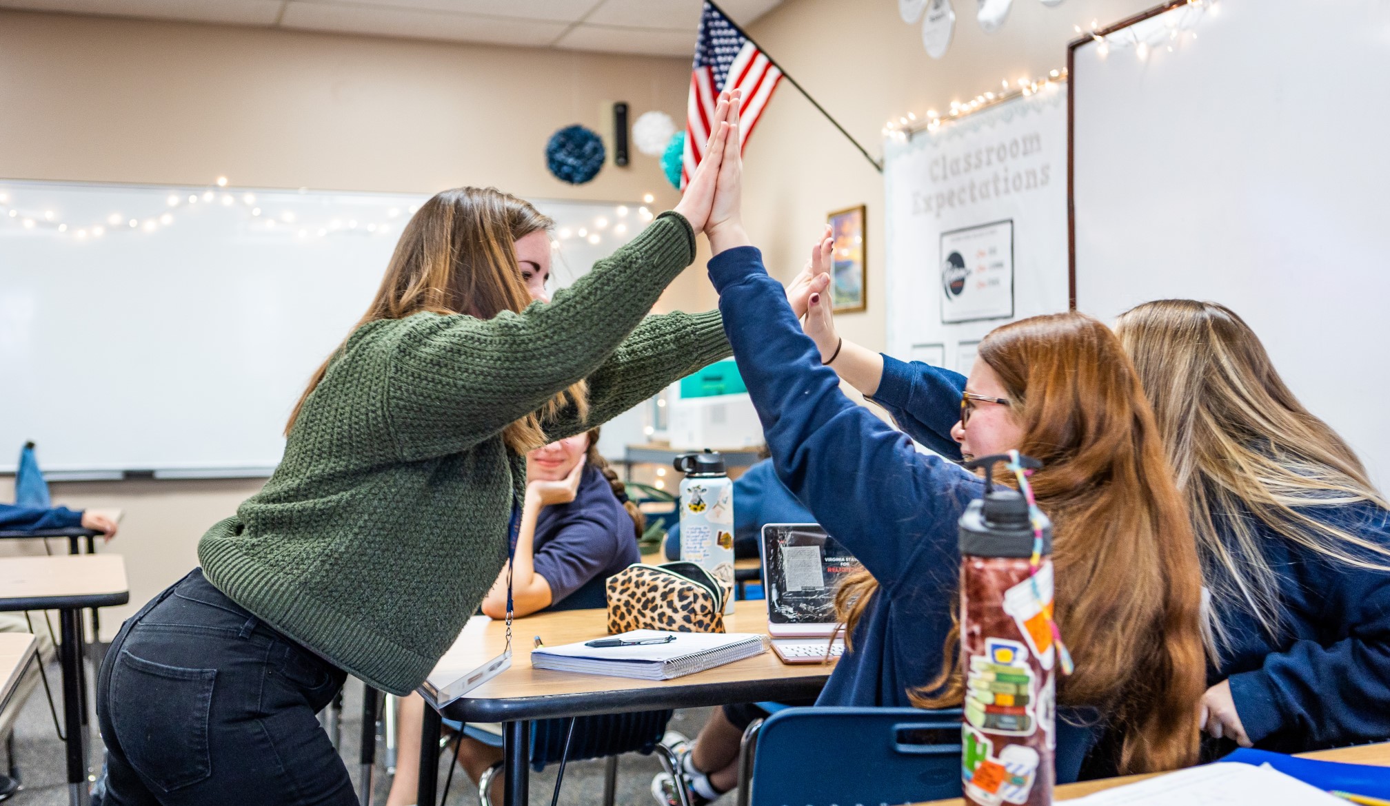 A Concordia student sharing a high five with two of her students.