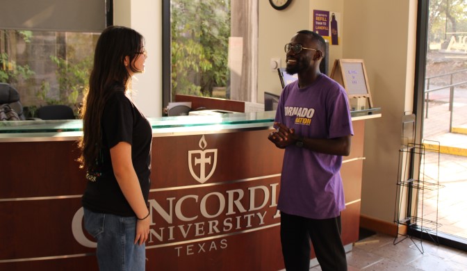 Jimmy Nkone in the Welcome Center with a student