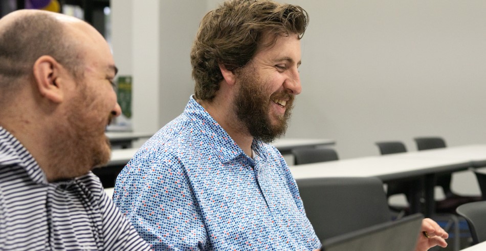 Graduate student working with technology in a collaborative setting