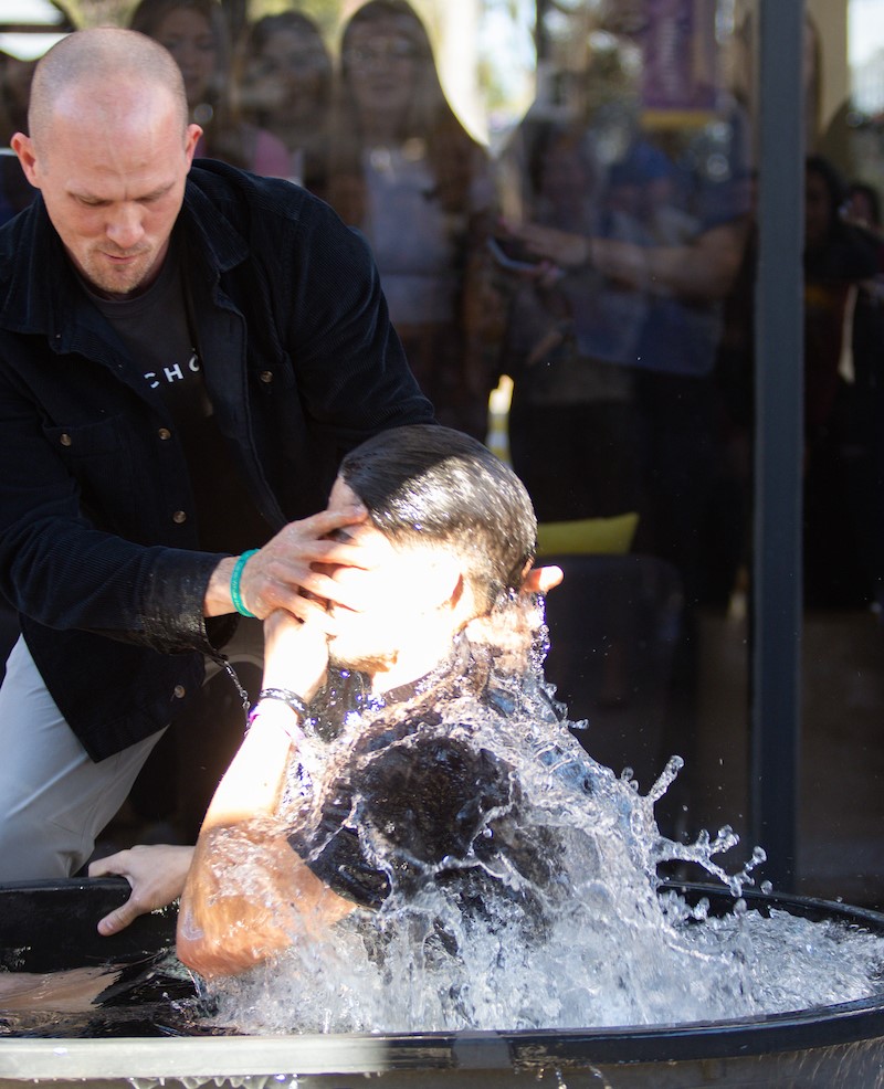 Pastor Jake Boessling baptizing a student